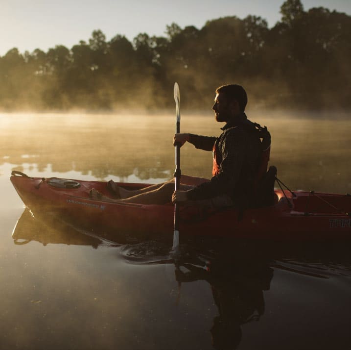 man kayaking in the misty lake cooley near spartanburg